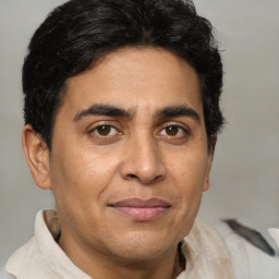 Joyful latino adult male with short  brown hair and brown eyes
