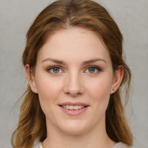 Joyful white young-adult female with medium  brown hair and green eyes