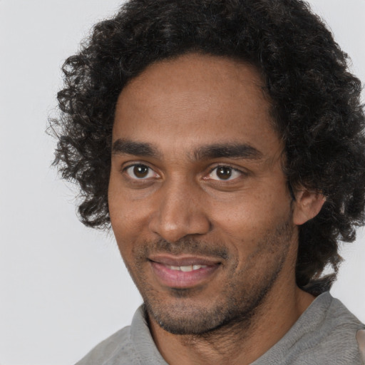 Joyful black adult male with short  black hair and brown eyes