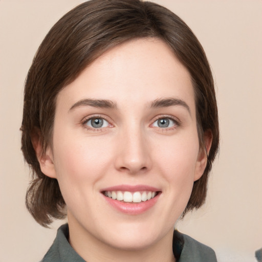 Joyful white young-adult female with medium  brown hair and green eyes