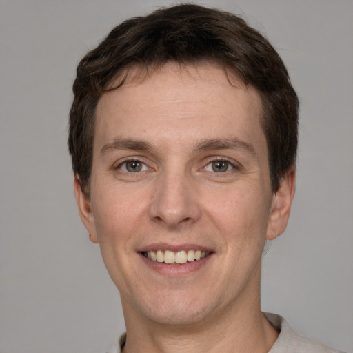 Joyful white adult male with short  brown hair and grey eyes