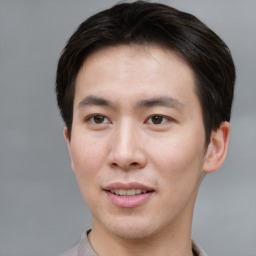 Joyful asian young-adult male with short  brown hair and brown eyes