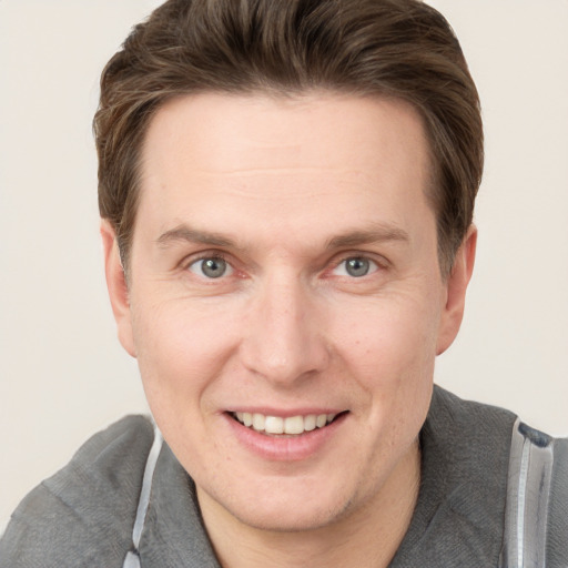 Joyful white adult male with short  brown hair and grey eyes