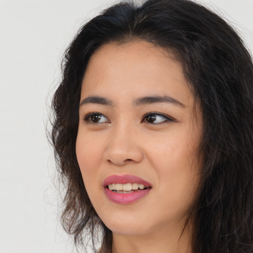 Joyful asian young-adult female with long  brown hair and brown eyes