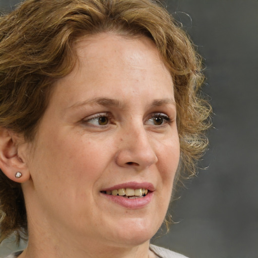 Joyful white adult female with medium  brown hair and brown eyes