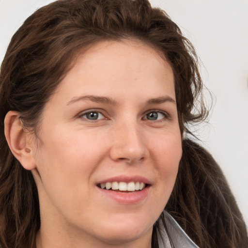 Joyful white young-adult female with long  brown hair and grey eyes