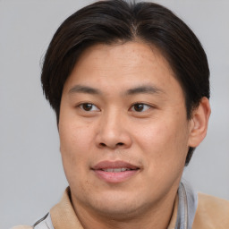 Joyful asian adult male with short  brown hair and brown eyes