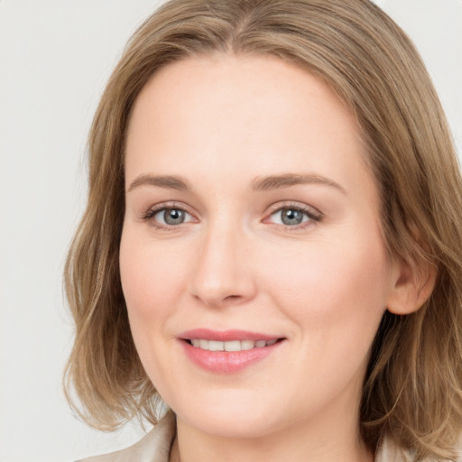 Joyful white young-adult female with long  brown hair and blue eyes