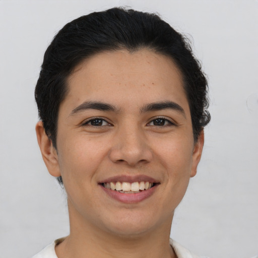 Joyful latino young-adult male with short  brown hair and brown eyes