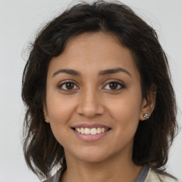 Joyful latino young-adult female with medium  brown hair and brown eyes