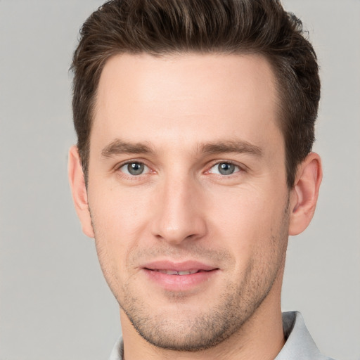 Joyful white young-adult male with short  brown hair and grey eyes