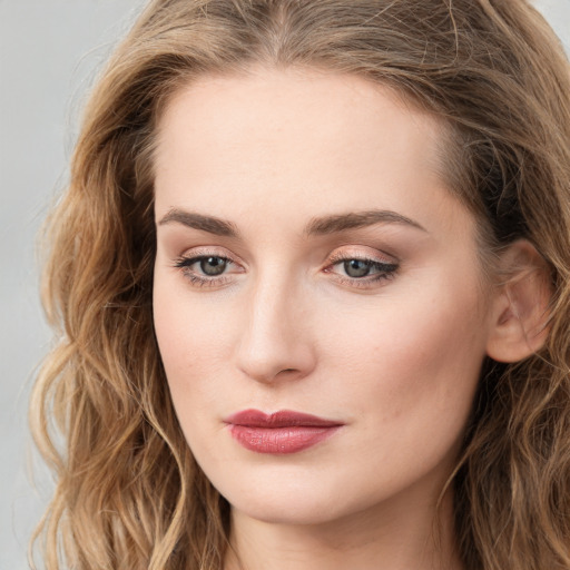 Joyful white young-adult female with long  brown hair and green eyes