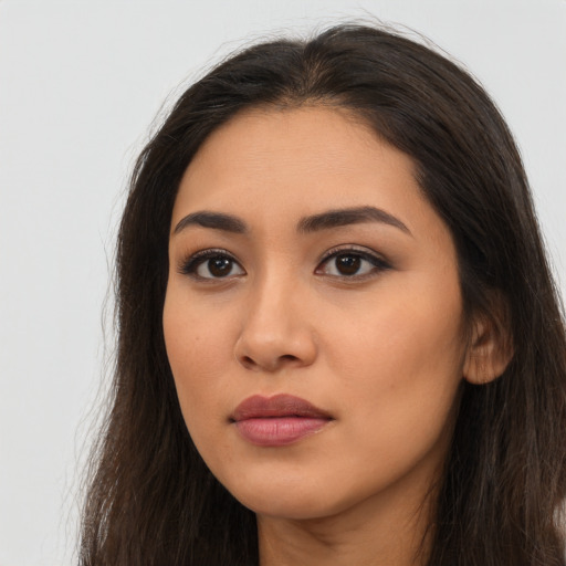 Joyful latino young-adult female with long  brown hair and brown eyes