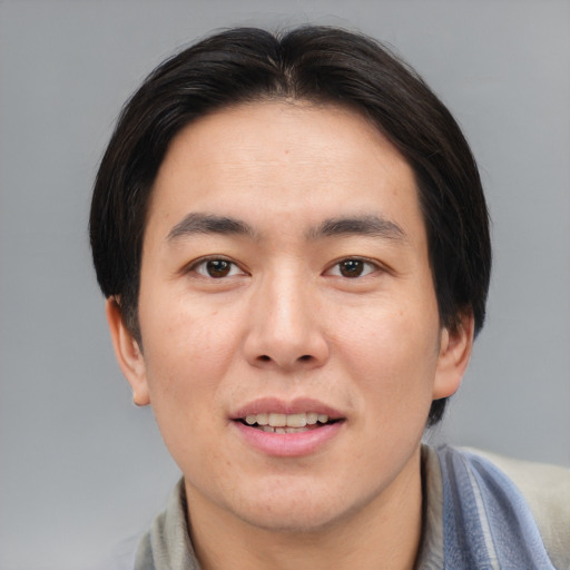 Joyful asian young-adult male with medium  brown hair and brown eyes