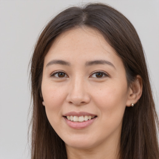 Joyful white young-adult female with long  brown hair and brown eyes