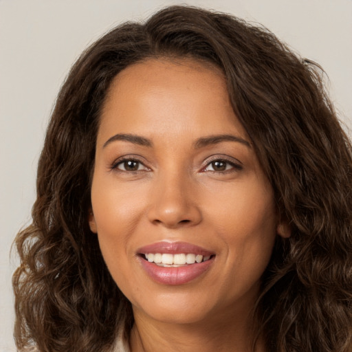 Joyful white young-adult female with long  brown hair and brown eyes