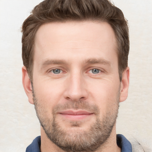 Joyful white young-adult male with short  brown hair and grey eyes