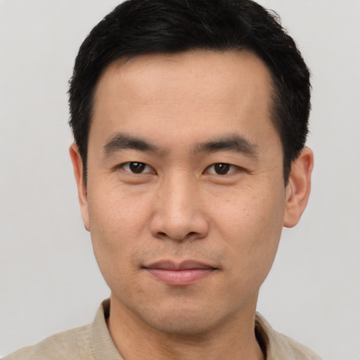 Joyful asian young-adult male with short  black hair and brown eyes
