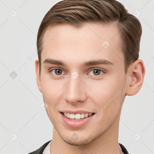 Joyful white young-adult male with short  brown hair and grey eyes