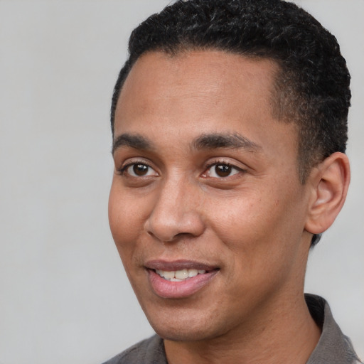 Joyful black young-adult male with short  black hair and brown eyes