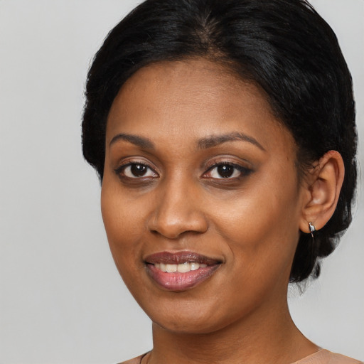 Joyful black adult female with medium  black hair and brown eyes