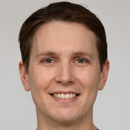 Joyful white adult male with short  brown hair and grey eyes