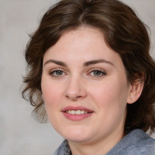 Joyful white young-adult female with medium  brown hair and blue eyes