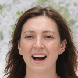 Joyful white adult female with long  brown hair and brown eyes