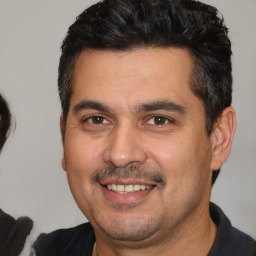 Joyful white young-adult male with short  black hair and brown eyes