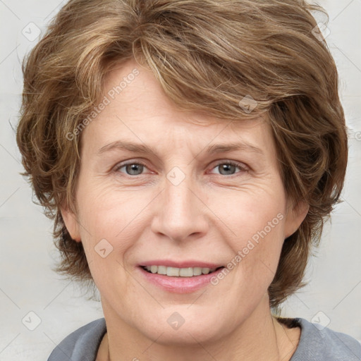 Joyful white adult female with medium  brown hair and grey eyes