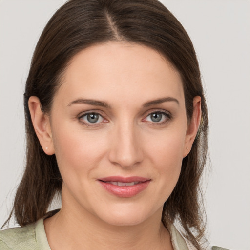 Joyful white young-adult female with medium  brown hair and grey eyes