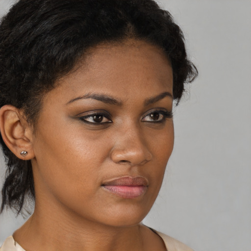 Joyful black young-adult female with medium  brown hair and brown eyes