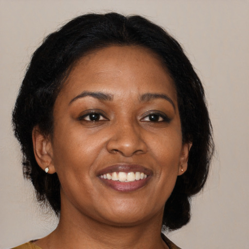 Joyful black adult female with medium  brown hair and brown eyes