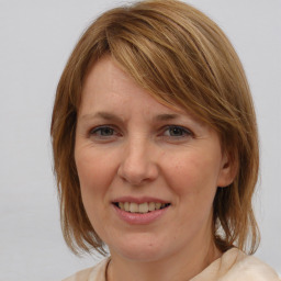 Joyful white adult female with medium  brown hair and blue eyes