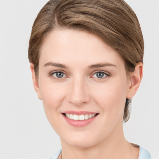 Joyful white young-adult female with short  brown hair and grey eyes