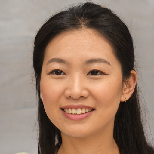 Joyful asian young-adult female with long  brown hair and brown eyes