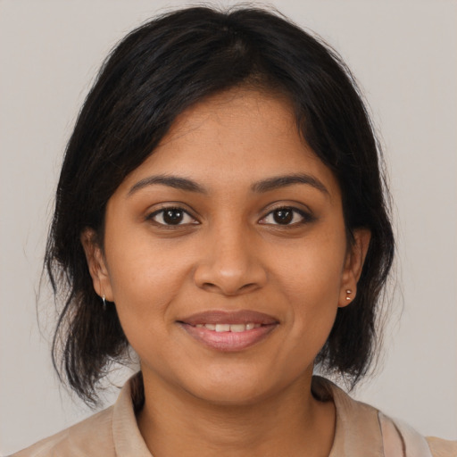 Joyful black young-adult female with medium  brown hair and brown eyes