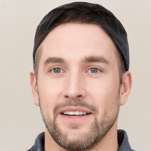 Joyful white young-adult male with short  black hair and brown eyes