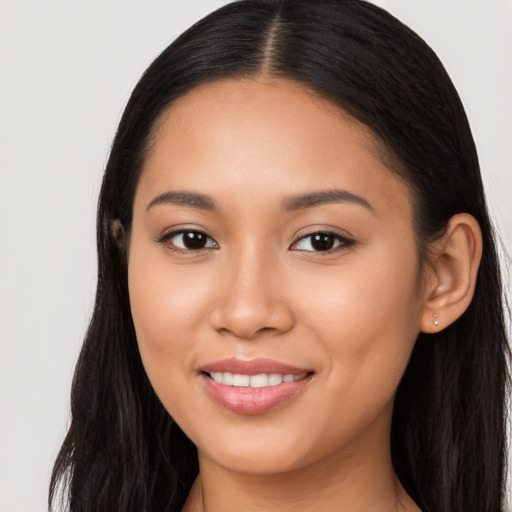 Joyful latino young-adult female with long  brown hair and brown eyes