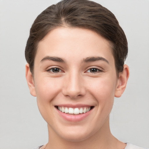 Joyful white young-adult female with short  brown hair and brown eyes