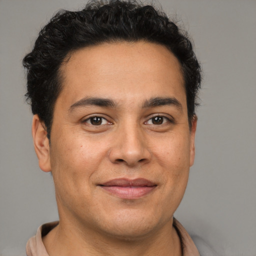 Joyful latino young-adult male with short  brown hair and brown eyes