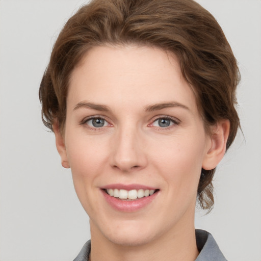 Joyful white young-adult female with short  brown hair and grey eyes