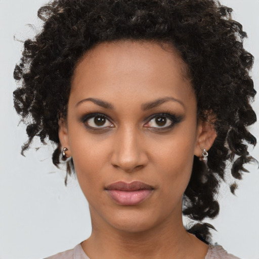 Joyful black young-adult female with medium  brown hair and brown eyes