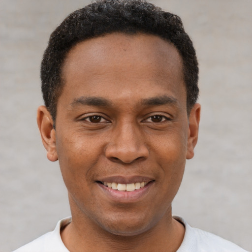 Joyful latino young-adult male with short  brown hair and brown eyes