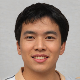 Joyful asian young-adult male with short  brown hair and brown eyes