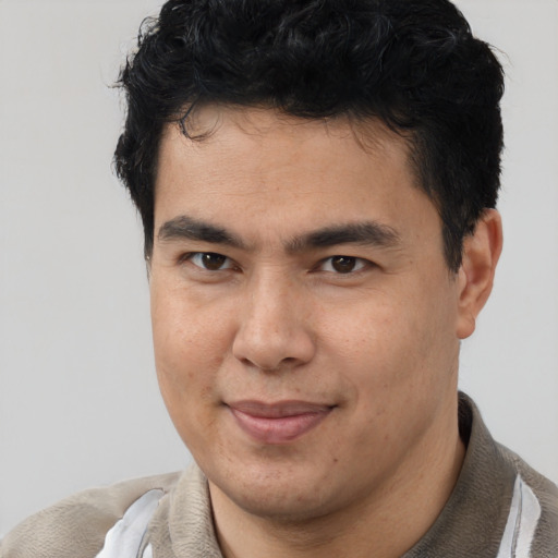 Joyful latino young-adult male with short  brown hair and brown eyes