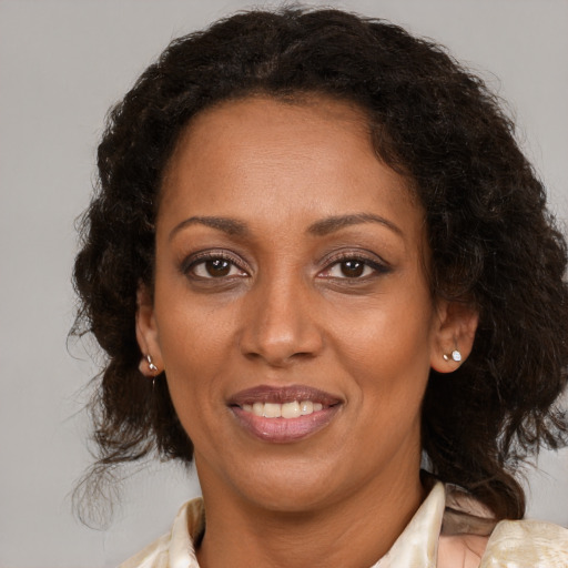 Joyful black adult female with medium  brown hair and brown eyes