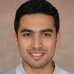 Joyful white young-adult male with short  black hair and brown eyes