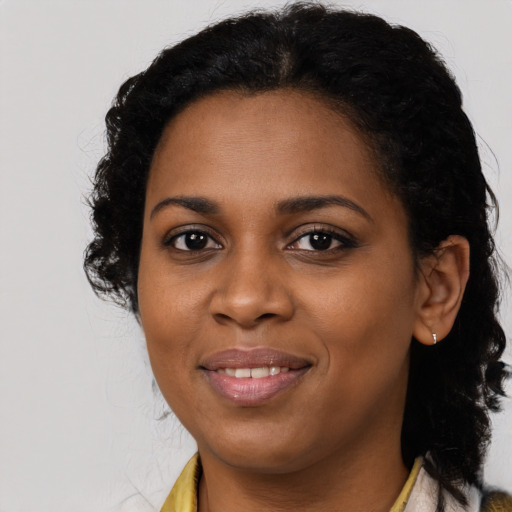 Joyful black young-adult female with long  brown hair and brown eyes
