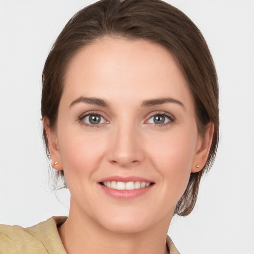 Joyful white young-adult female with medium  brown hair and grey eyes